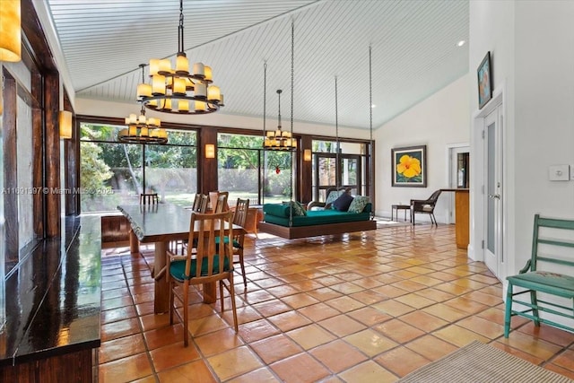 dining area with high vaulted ceiling, a notable chandelier, baseboards, and tile patterned floors