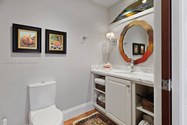 13470 SW 67th Ave, Pinecrest, FL 33156 - half bathroom featuring toilet, vanity, baseboards, and wood finished floors