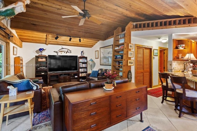 living area featuring ceiling fan, rail lighting, light tile patterned floors, wooden ceiling, and vaulted ceiling with beams