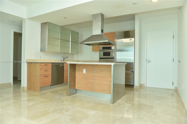 kitchen featuring appliances with stainless steel finishes, sink, range hood, and a kitchen island