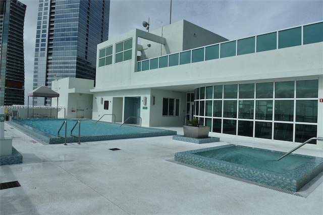 view of swimming pool featuring a patio area and a community hot tub