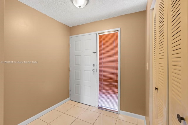 tiled foyer entrance with a textured ceiling