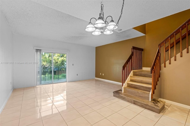 tiled empty room featuring a textured ceiling and an inviting chandelier