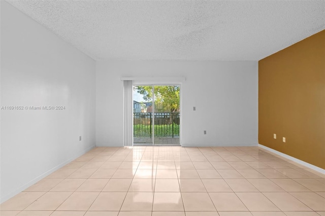 tiled spare room with a textured ceiling