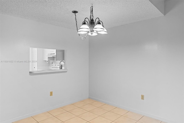 tiled empty room featuring a textured ceiling