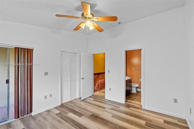 unfurnished bedroom with ceiling fan, light hardwood / wood-style floors, a closet, and ensuite bathroom