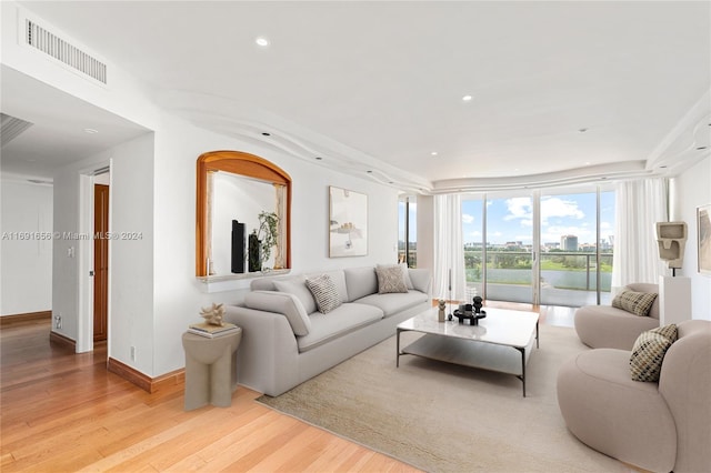 living room with light hardwood / wood-style floors and a wall of windows