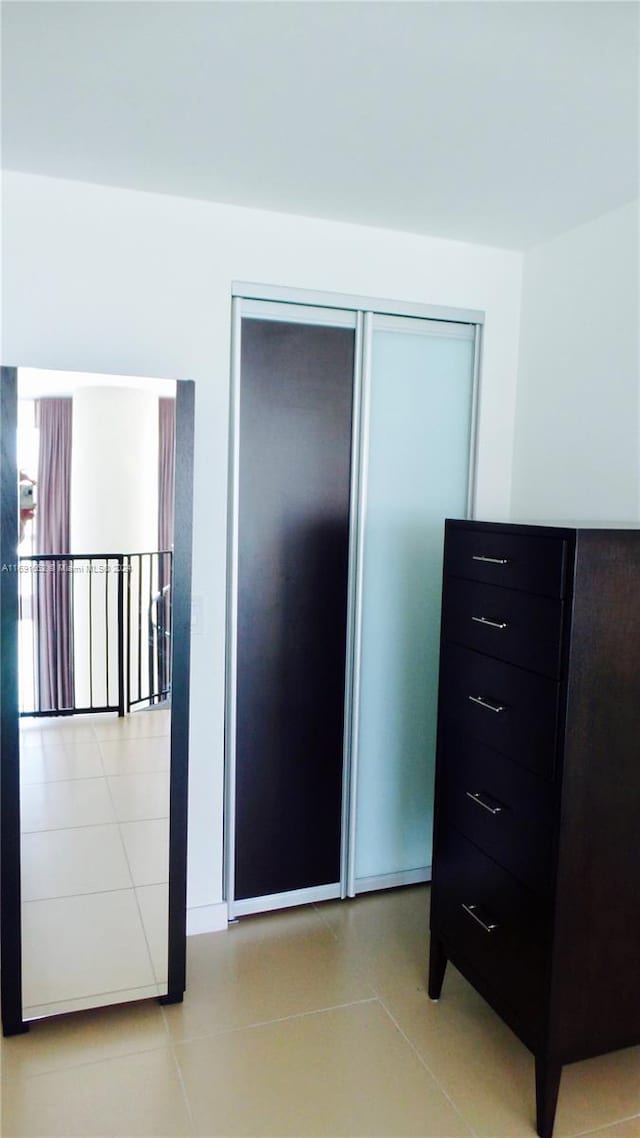 bedroom with a closet and light tile patterned flooring