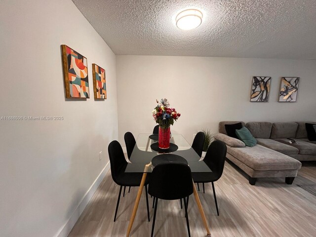 living room featuring light wood-type flooring and a textured ceiling