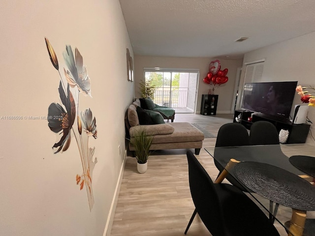 living room featuring light hardwood / wood-style floors and a textured ceiling