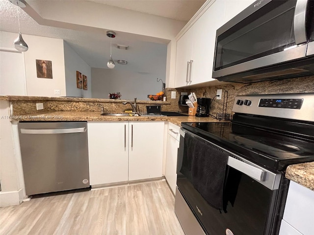 kitchen featuring white cabinetry, appliances with stainless steel finishes, stone countertops, and pendant lighting