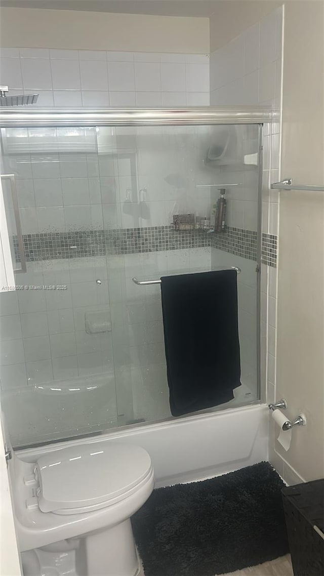 bathroom featuring toilet and enclosed tub / shower combo