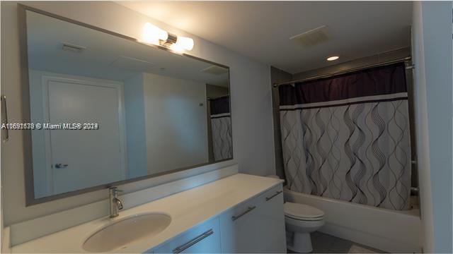 full bathroom with vanity, toilet, and shower / tub combo