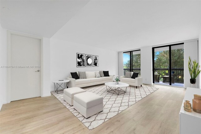 living room with light wood-type flooring and floor to ceiling windows