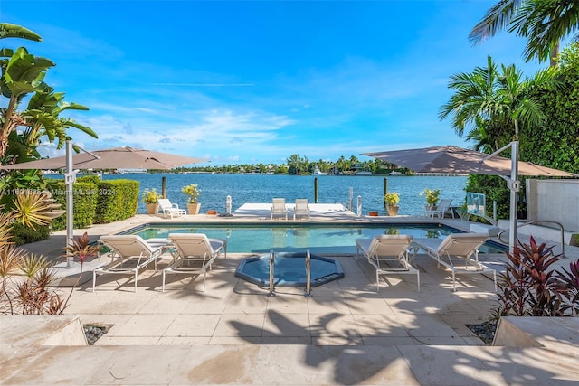 view of swimming pool with a water view and a patio area