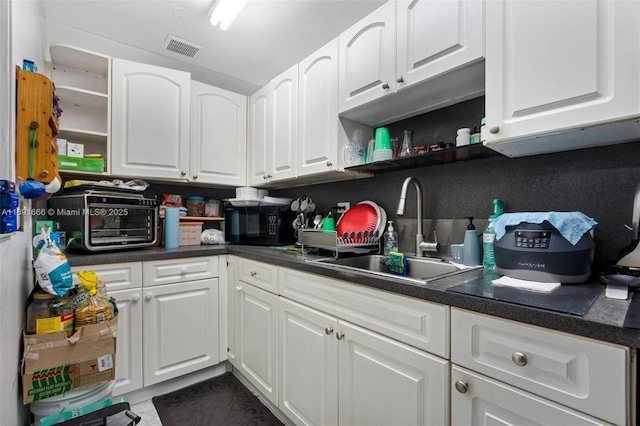 kitchen featuring sink and white cabinetry