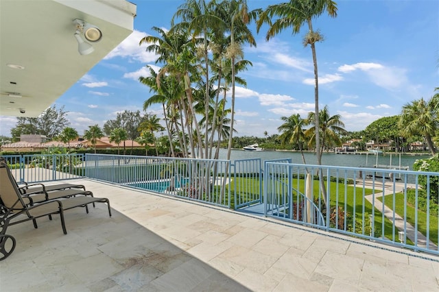 view of patio with a water view and a fenced in pool