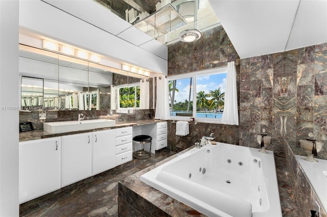 bathroom featuring tile walls, vanity, and a relaxing tiled tub