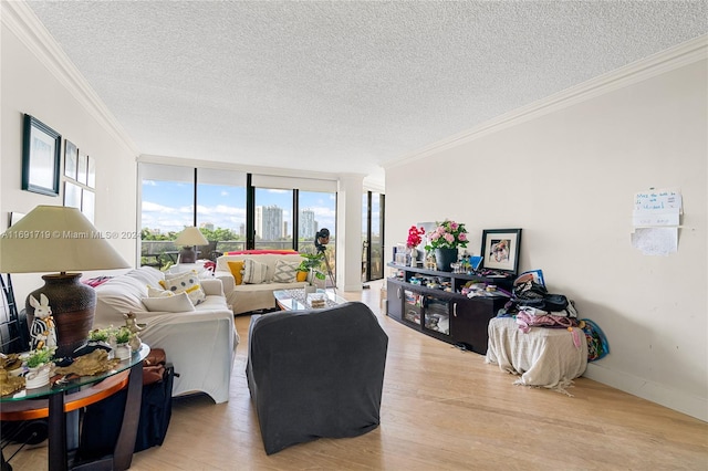 living room with a textured ceiling, hardwood / wood-style flooring, floor to ceiling windows, and ornamental molding