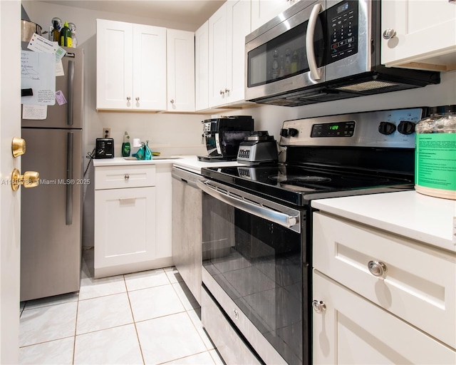 kitchen with light tile patterned floors, stainless steel appliances, light countertops, and white cabinetry