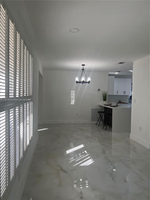 unfurnished living room with a notable chandelier