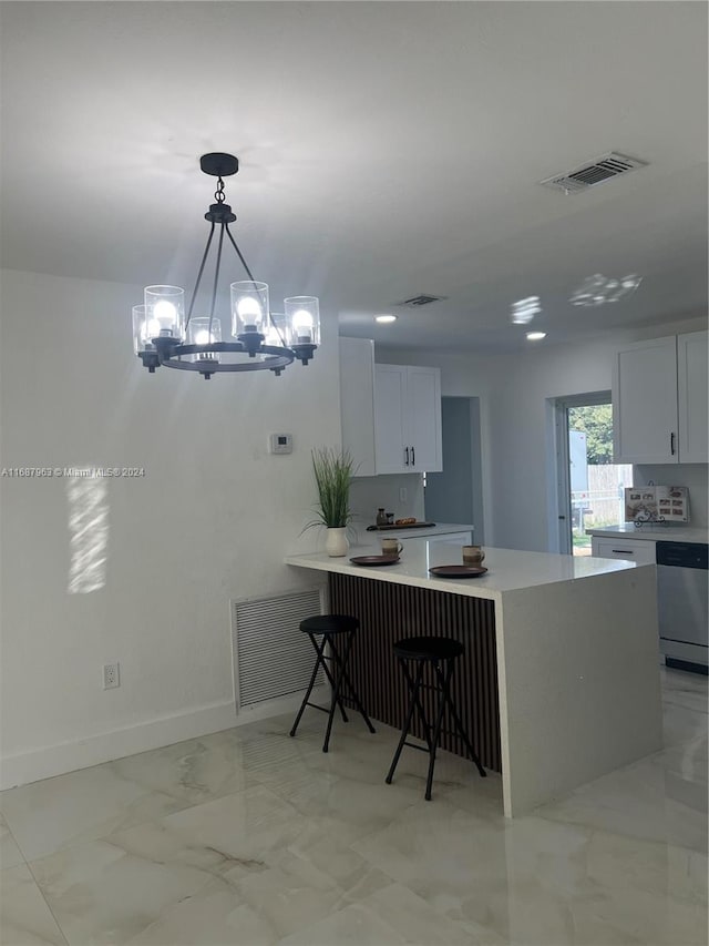 kitchen featuring a kitchen bar, an inviting chandelier, hanging light fixtures, white cabinets, and dishwasher