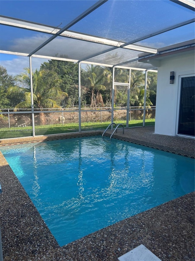 view of swimming pool with a lanai