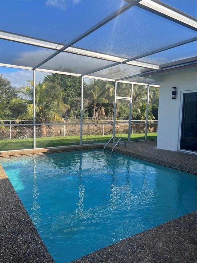 view of pool featuring glass enclosure