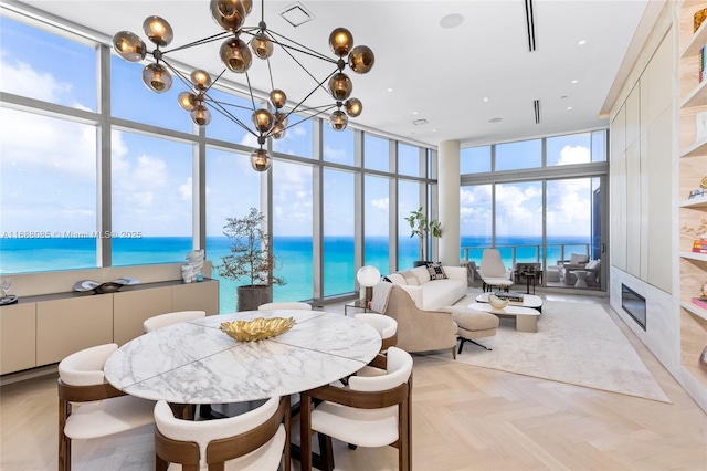 sunroom / solarium featuring a water view and an inviting chandelier