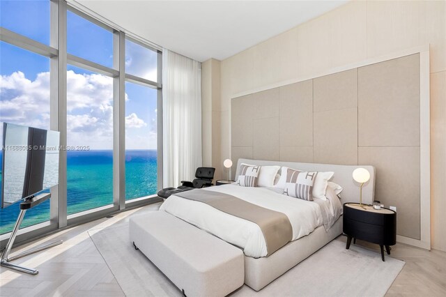 bedroom with access to outside, floor to ceiling windows, light parquet floors, and multiple windows