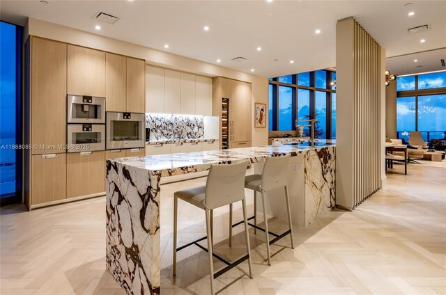 kitchen featuring light stone countertops, light parquet floors, a breakfast bar, and oven