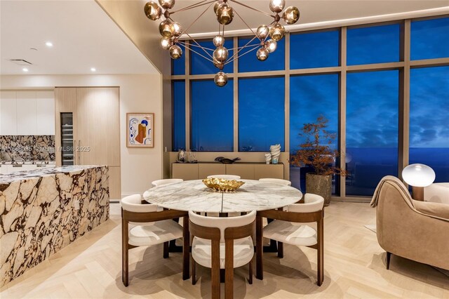 dining room featuring a notable chandelier and light parquet flooring