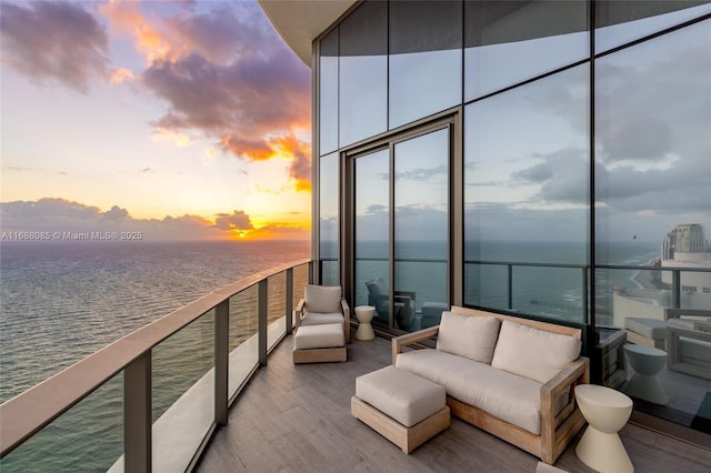 view of dock with outdoor lounge area, a water view, and a balcony