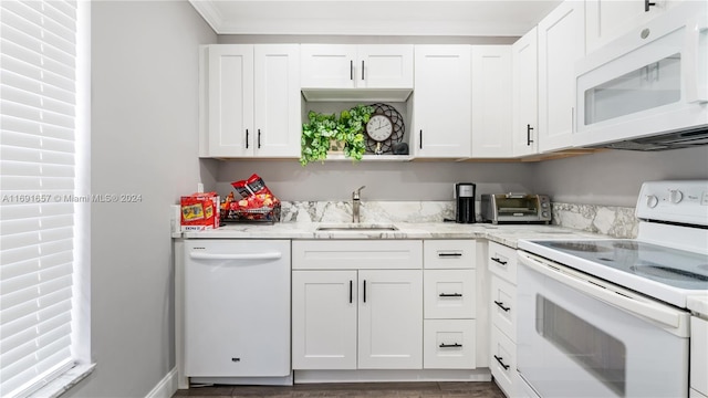 kitchen with light stone countertops, white appliances, sink, and white cabinets