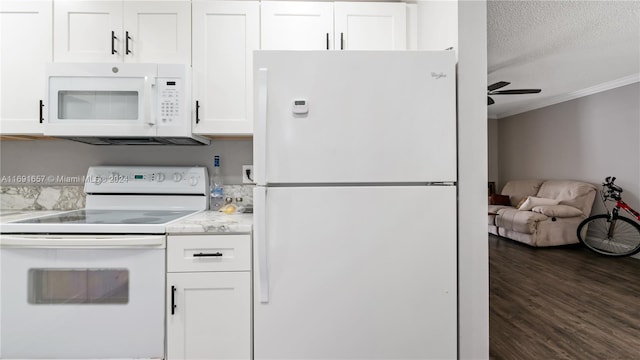 kitchen with white cabinetry, a textured ceiling, white appliances, crown molding, and dark wood-type flooring