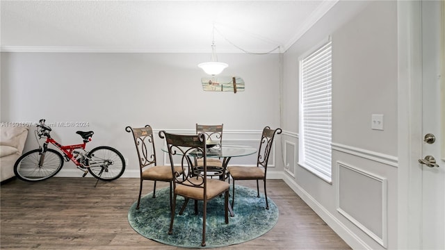 dining space with dark wood-type flooring and ornamental molding