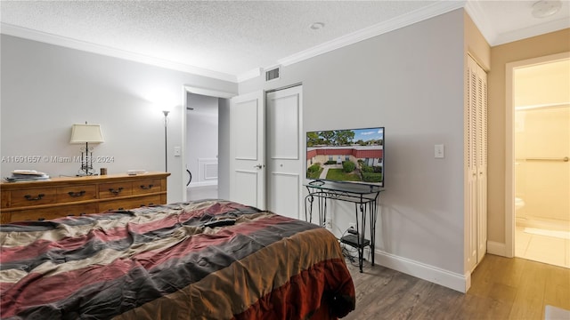 bedroom featuring hardwood / wood-style flooring, a textured ceiling, and crown molding