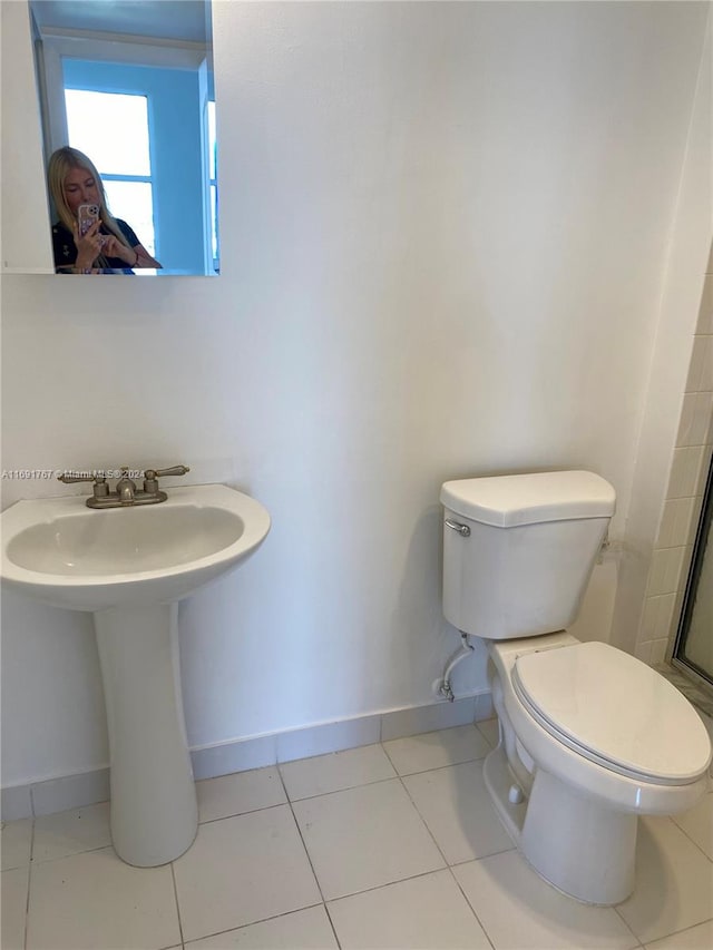 bathroom featuring tile patterned flooring, toilet, and sink