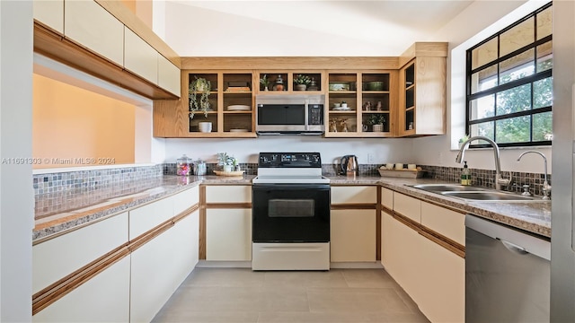 kitchen featuring stainless steel appliances, white cabinets, sink, and vaulted ceiling