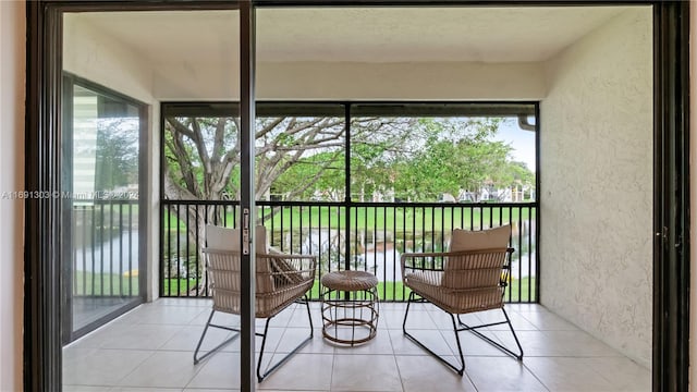 sunroom with a water view and a healthy amount of sunlight