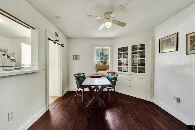 dining room featuring baseboards, hardwood / wood-style floors, and a ceiling fan