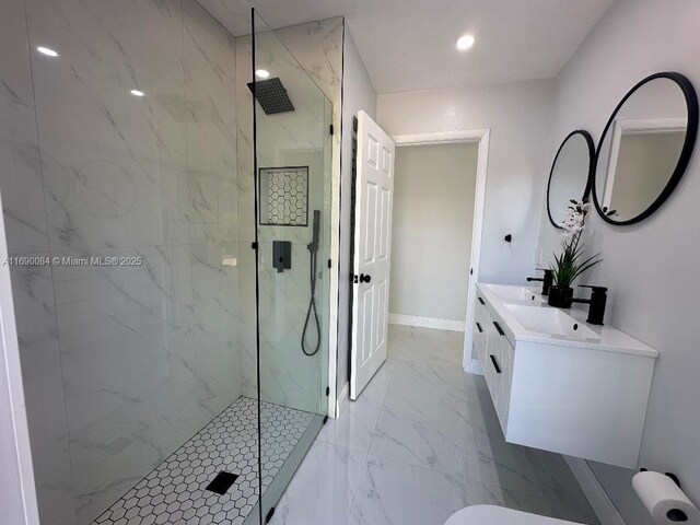 bathroom featuring tiled shower and vanity