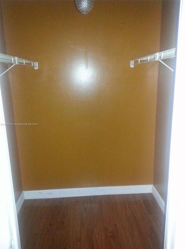 walk in closet with hardwood / wood-style floors