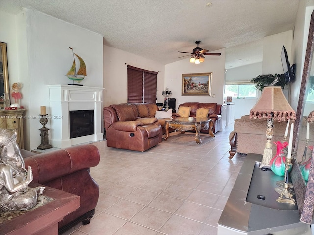 living room featuring ceiling fan, light tile patterned floors, a textured ceiling, and lofted ceiling