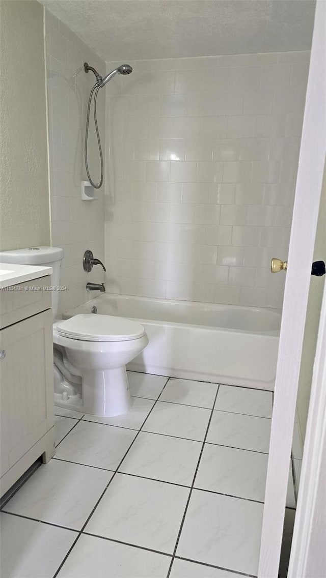 full bathroom with vanity, a textured ceiling, tiled shower / bath combo, tile patterned flooring, and toilet