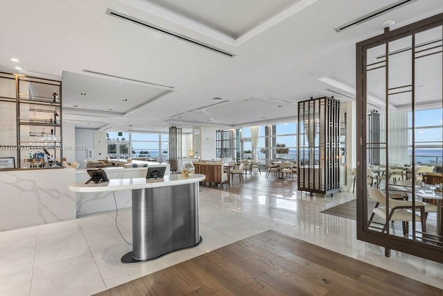 tiled living room featuring a tray ceiling and floor to ceiling windows