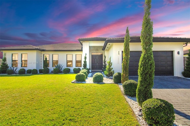 view of front of home with a lawn and a garage