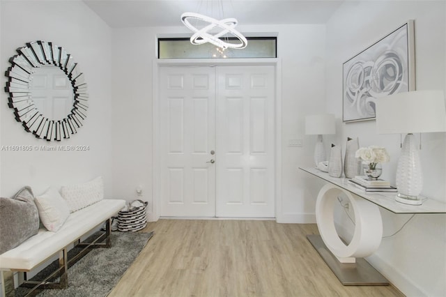 foyer entrance featuring light wood-type flooring and an inviting chandelier