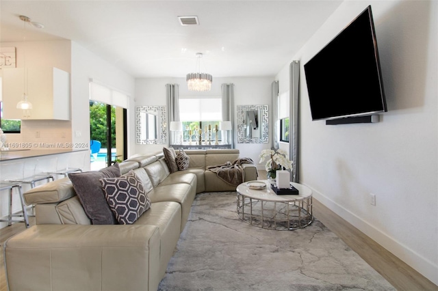 living room featuring a chandelier and light hardwood / wood-style floors