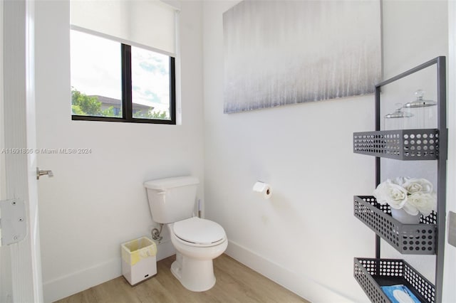 bathroom with hardwood / wood-style flooring and toilet